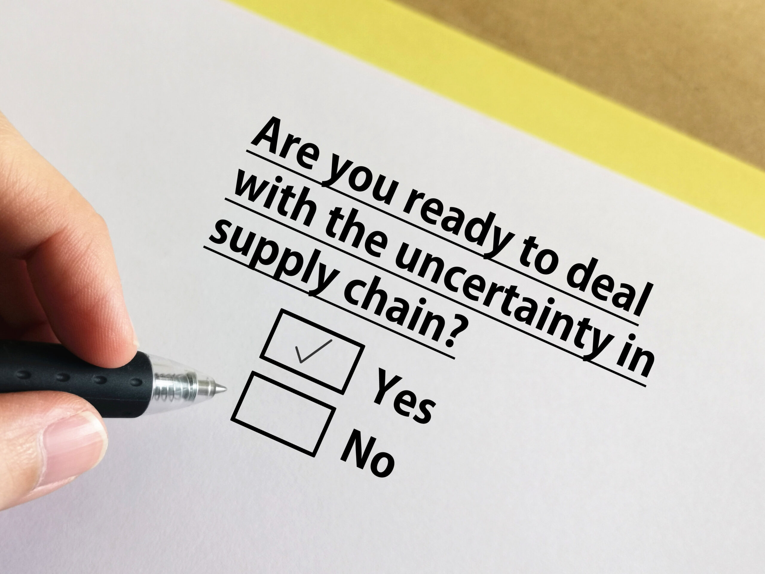 A person holds a pen and is taking a questionnaire. On the paper is the question